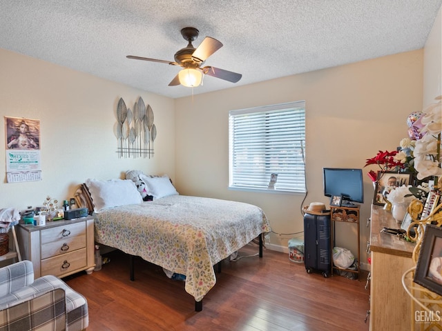 bedroom with a textured ceiling, ceiling fan, and dark wood-type flooring