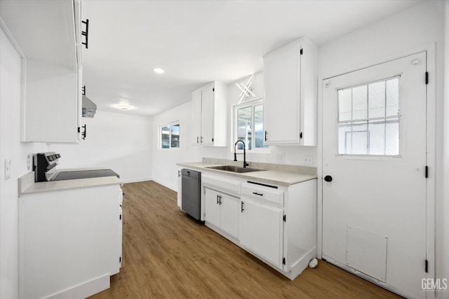 kitchen with light wood finished floors, stainless steel appliances, white cabinetry, and light countertops