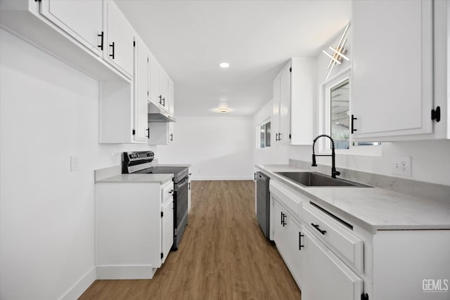 kitchen with appliances with stainless steel finishes, light countertops, white cabinets, and a sink