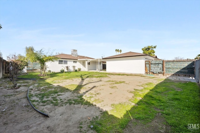 back of property with a yard, a fenced backyard, and stucco siding