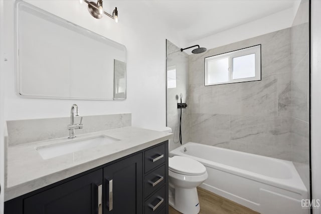 full bathroom featuring toilet, bathing tub / shower combination, vanity, and wood finished floors