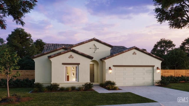 mediterranean / spanish house featuring a garage, a front yard, concrete driveway, and stucco siding