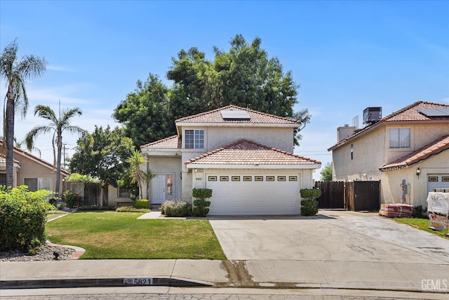 5821 Willowcrest St, Bakersfield, CA 93313 - mediterranean / spanish house featuring a tiled roof, concrete driveway, solar panels, stucco siding, and an attached garage