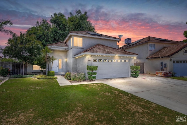 5821 Willowcrest St, Bakersfield, CA 93313 - mediterranean / spanish-style house featuring concrete driveway, an attached garage, a tiled roof, solar panels, and stucco siding