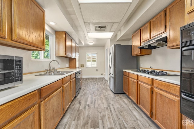 1701 Elm St, Bakersfield, CA 93301 - kitchen featuring black appliances, a sink, light wood-type flooring, light countertops, and under cabinet range hood
