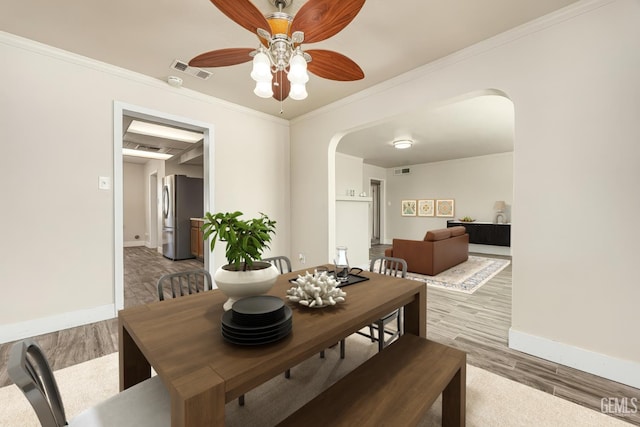 1701 Elm St, Bakersfield, CA 93301 - dining space with arched walkways, baseboards, wood finished floors, a ceiling fan, and ornamental molding