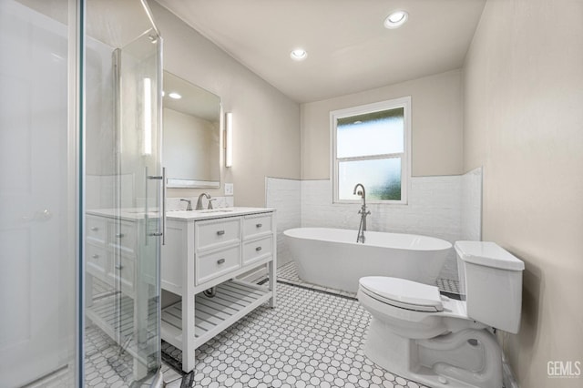 1701 Elm St, Bakersfield, CA 93301 - bathroom with a stall shower, vanity, a soaking tub, tile walls, and wainscoting