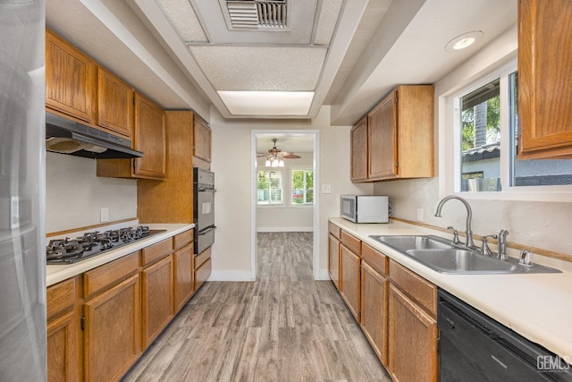 1701 Elm St, Bakersfield, CA 93301 - kitchen featuring black appliances, a sink, under cabinet range hood, a warming drawer, and light countertops