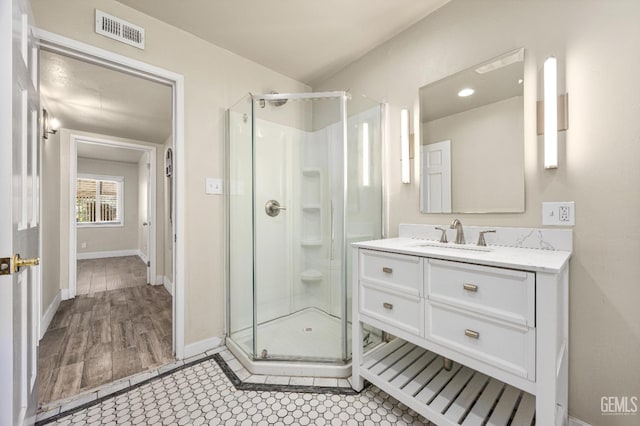 1701 Elm St, Bakersfield, CA 93301 - full bath with a shower stall, vanity, baseboards, and wood finished floors