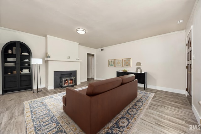 1701 Elm St, Bakersfield, CA 93301 - living area featuring baseboards, light wood-style flooring, crown molding, and a wood stove