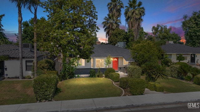 1701 Elm St, Bakersfield, CA 93301 - obstructed view of property featuring a lawn and stucco siding