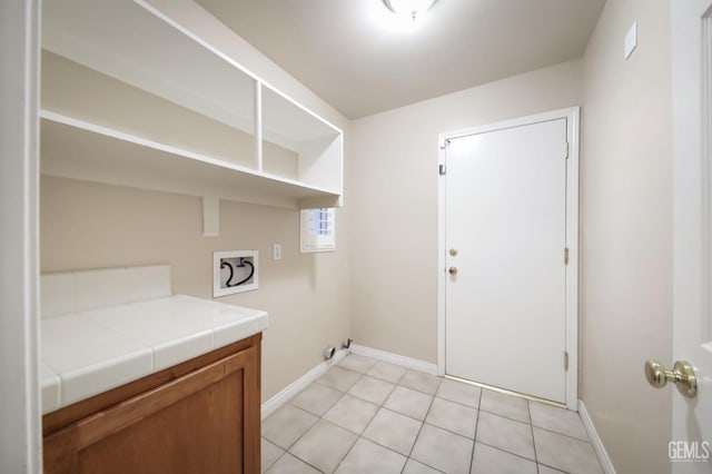 laundry room featuring hookup for a washing machine and light tile patterned flooring