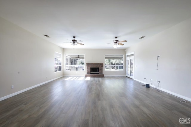 unfurnished living room with ceiling fan, a fireplace, and dark hardwood / wood-style flooring