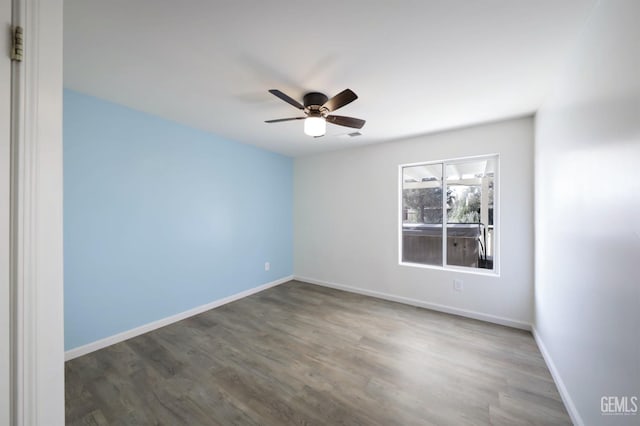 empty room with ceiling fan and dark hardwood / wood-style flooring