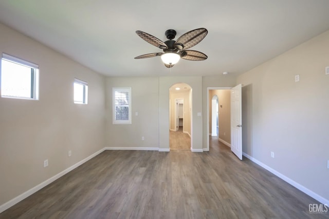 empty room with ceiling fan and dark hardwood / wood-style flooring