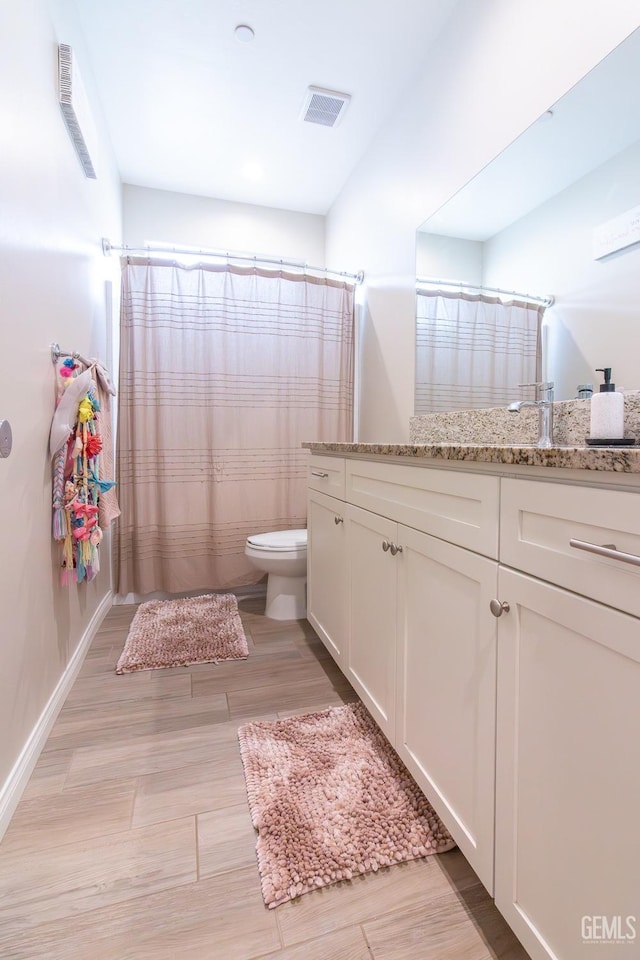 bathroom with toilet, a shower with curtain, visible vents, and vanity