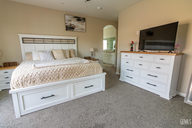 bedroom with arched walkways, carpet, and ensuite bath