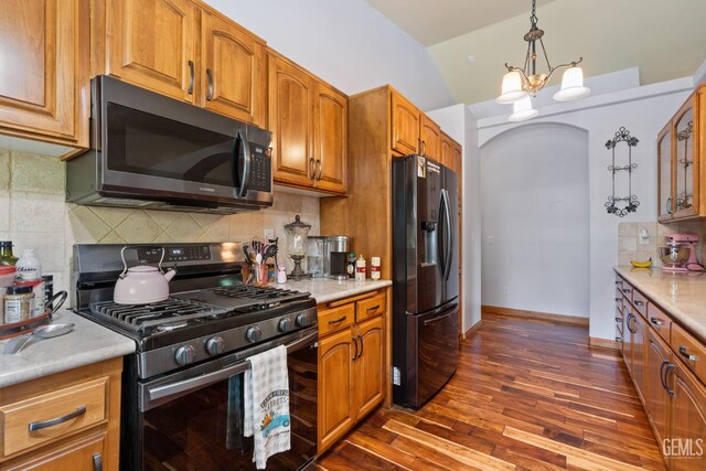 3606 Azure Dr, Bakersfield, CA 93312 - kitchen with stainless steel gas range, black fridge with ice dispenser, dark wood-style flooring, a chandelier, and light countertops