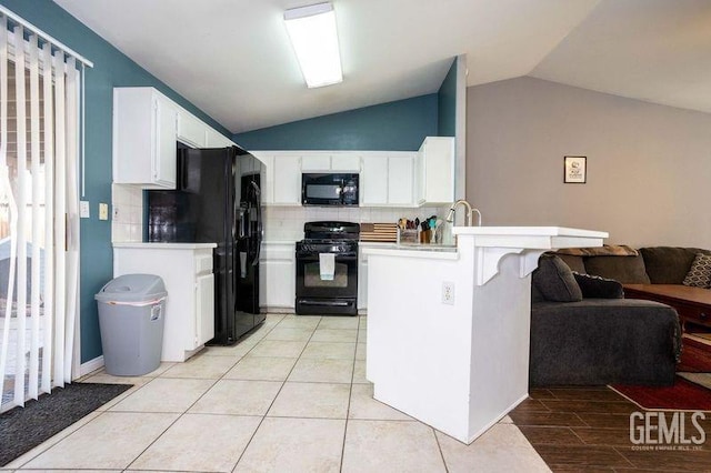 kitchen featuring black appliances, white cabinetry, lofted ceiling, decorative backsplash, and kitchen peninsula