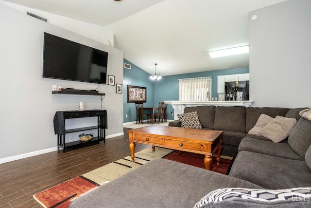 living room with dark hardwood / wood-style floors, a chandelier, and vaulted ceiling