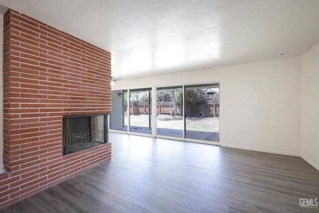 1312 Shattuck Ave, Bakersfield, CA 93305 - unfurnished living room featuring wood finished floors, a brick fireplace, and a ceiling fan