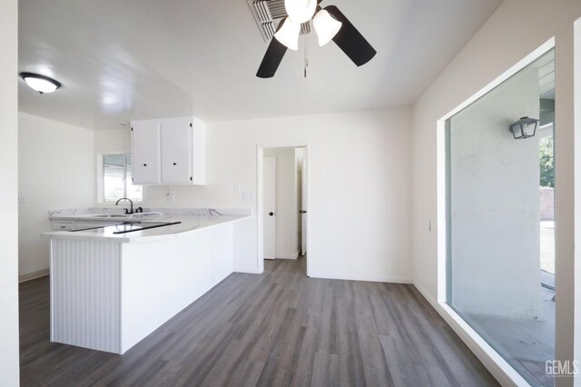 1312 Shattuck Ave, Bakersfield, CA 93305 - kitchen with dark wood-type flooring, ceiling fan, light countertops, white cabinetry, and a peninsula