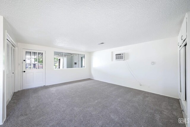 1312 Shattuck Ave, Bakersfield, CA 93305 - empty room featuring carpet, a textured ceiling, and a wall mounted AC