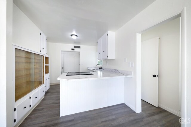 1312 Shattuck Ave, Bakersfield, CA 93305 - kitchen featuring white cabinetry, a peninsula, dark wood-style floors, and black electric stovetop