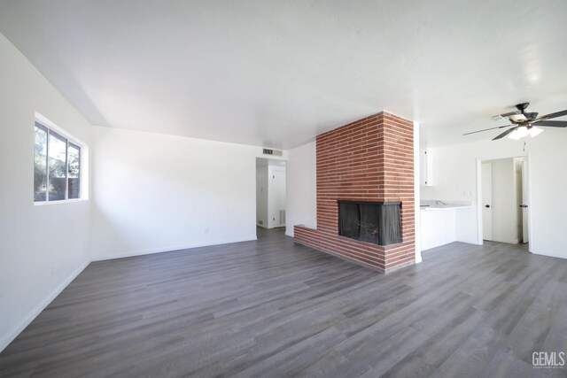 1312 Shattuck Ave, Bakersfield, CA 93305 - unfurnished living room featuring dark wood-style floors, a fireplace, and a ceiling fan