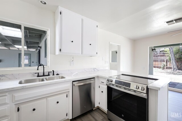 1312 Shattuck Ave, Bakersfield, CA 93305 - kitchen featuring appliances with stainless steel finishes, dark wood-style floors, a peninsula, white cabinets, and light stone countertops