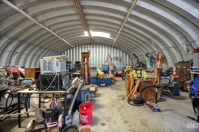 misc room with a garage, lofted ceiling, and unfinished concrete floors