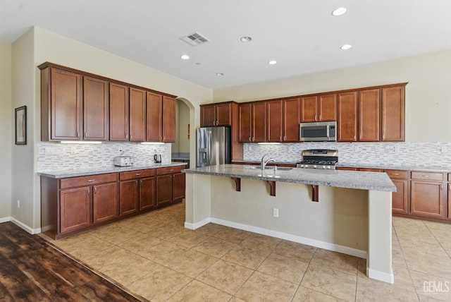 3420 Palagetto Pl, Bakersfield, CA 93314 - kitchen featuring stainless steel appliances, a sink, light stone counters, decorative backsplash, and recessed lighting