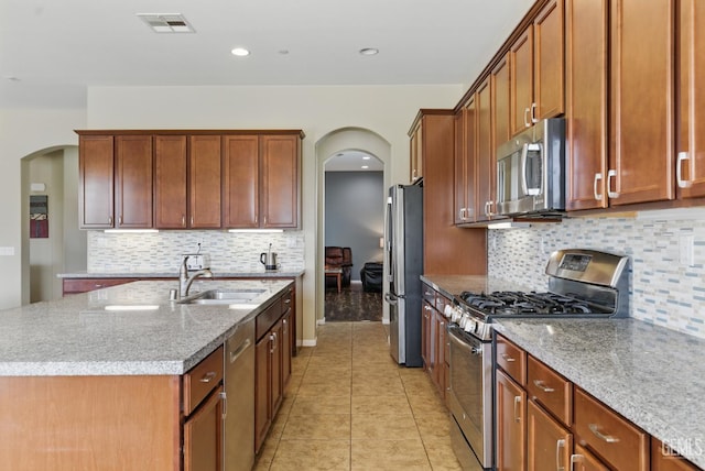 3420 Palagetto Pl, Bakersfield, CA 93314 - kitchen featuring stainless steel appliances, arched walkways, a sink, a center island with sink, and recessed lighting