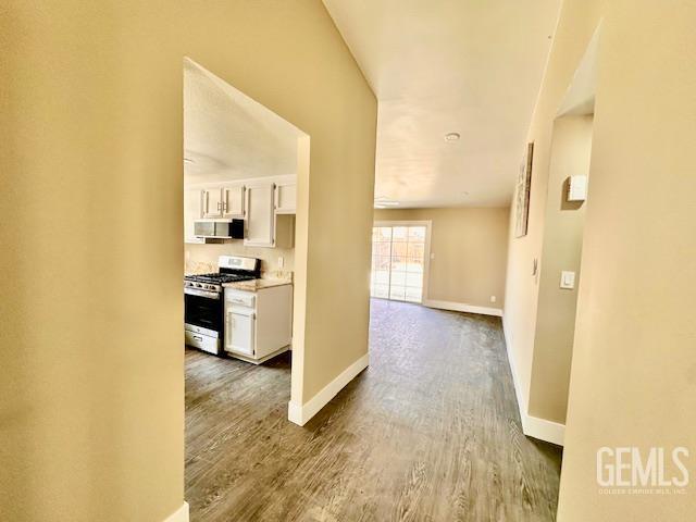 2004 Magdelena Ave, Bakersfield, CA 93307 - corridor with baseboards and dark wood-style flooring