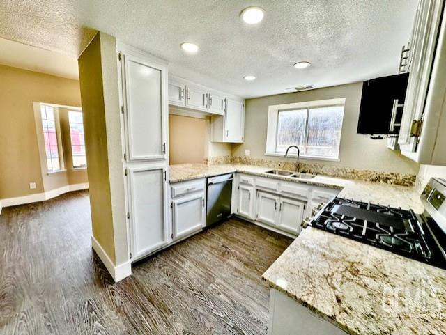 2004 Magdelena Ave, Bakersfield, CA 93307 - kitchen with a sink, stainless steel appliances, a textured ceiling, dark wood finished floors, and white cabinetry