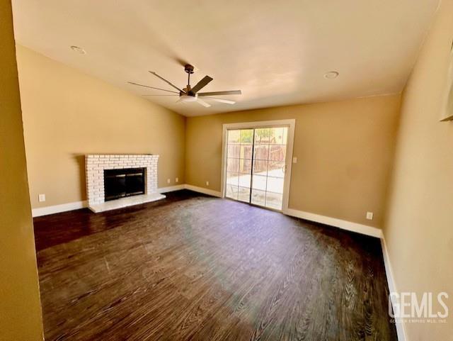2004 Magdelena Ave, Bakersfield, CA 93307 - unfurnished living room with a ceiling fan, dark wood-style flooring, baseboards, and a fireplace