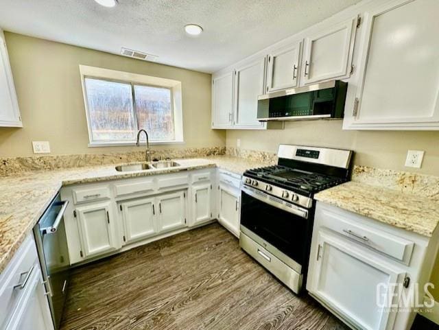 2004 Magdelena Ave, Bakersfield, CA 93307 - kitchen featuring stainless steel appliances, a sink, dark wood-style floors, and white cabinetry