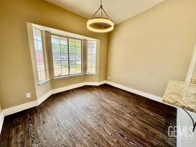 2004 Magdelena Ave, Bakersfield, CA 93307 - unfurnished dining area with dark wood-style floors and baseboards