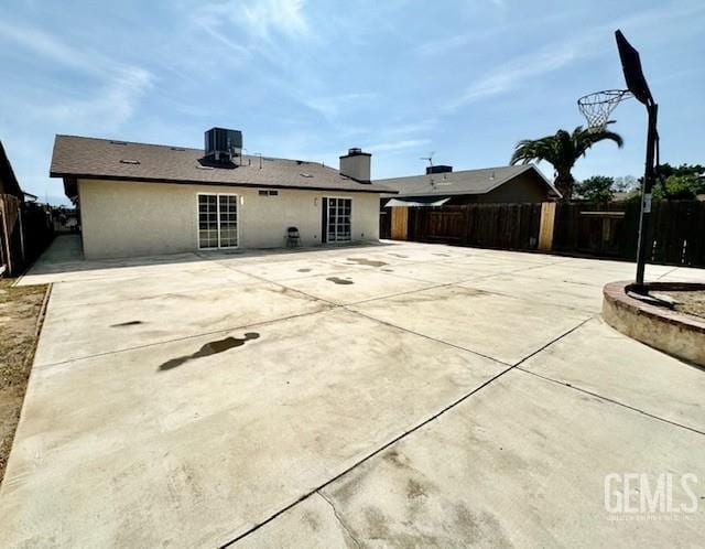 2004 Magdelena Ave, Bakersfield, CA 93307 - back of house with a fenced backyard, a patio, stucco siding, and central AC unit