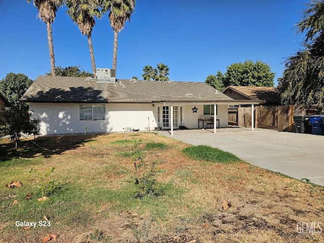 view of front of property featuring a patio area, french doors, and a front lawn