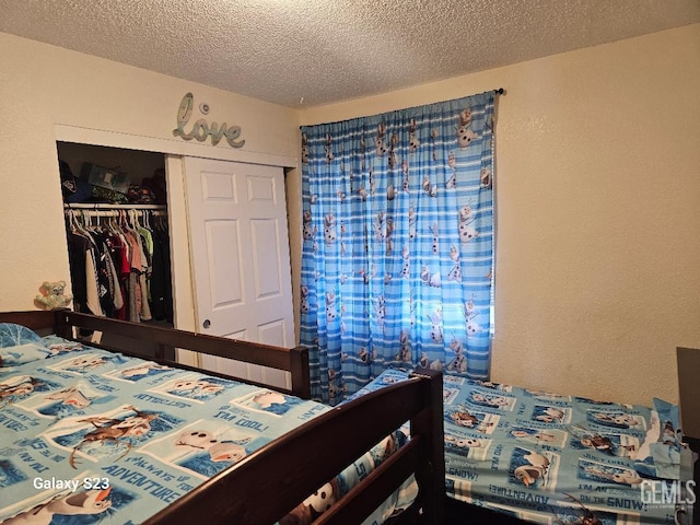 bedroom with a textured ceiling and a closet