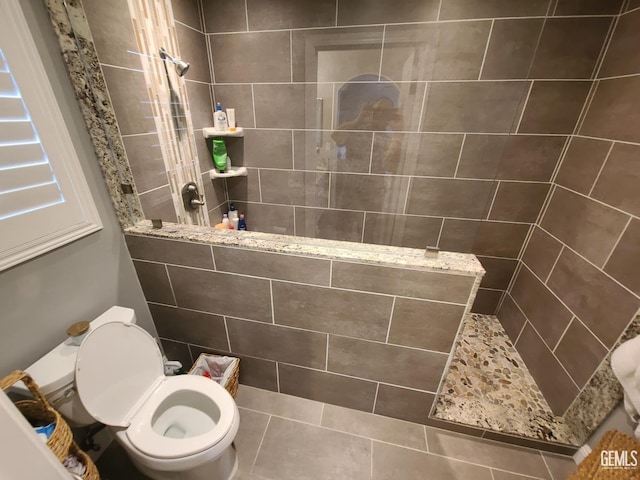 bathroom with toilet, a walk in shower, and tile patterned floors