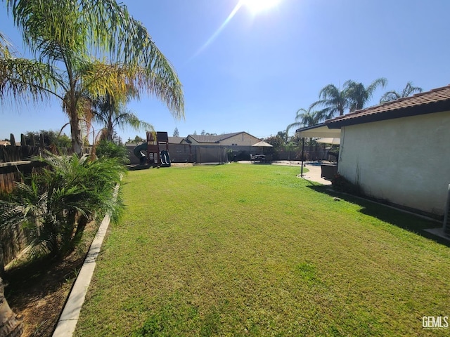 view of yard featuring a playground and a fenced backyard