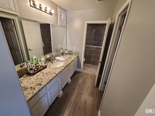 bathroom featuring toilet, wood finished floors, and vanity