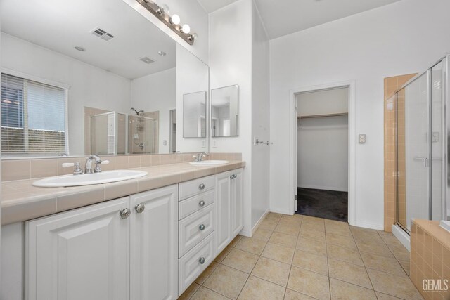 4702 Aviara Dr, Bakersfield, CA 93312 - bathroom featuring a stall shower, double vanity, tile patterned flooring, and a spacious closet