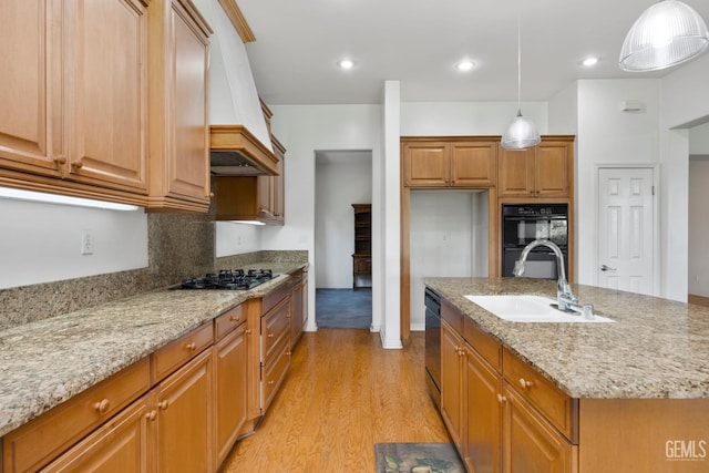4702 Aviara Dr, Bakersfield, CA 93312 - kitchen with a sink, black appliances, light wood-style floors, brown cabinets, and light stone counters