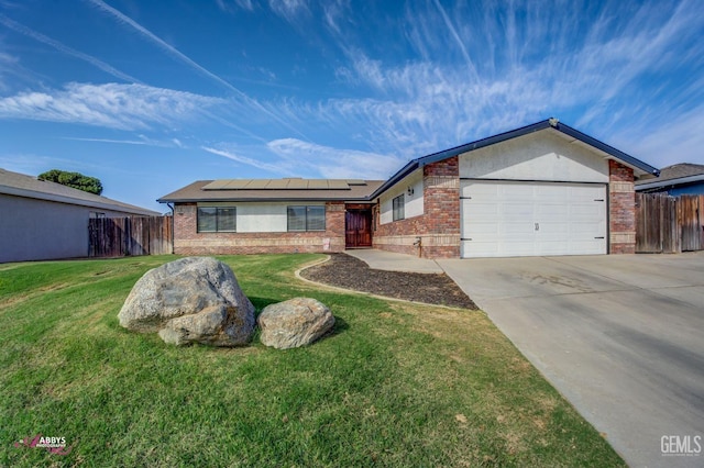 single story home with a front yard, solar panels, and a garage