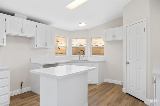 4500 Joshua Dr, Mountain Mesa, CA 93240 - kitchen featuring light wood-style flooring, white cabinetry, light countertops, a kitchen island, and lofted ceiling