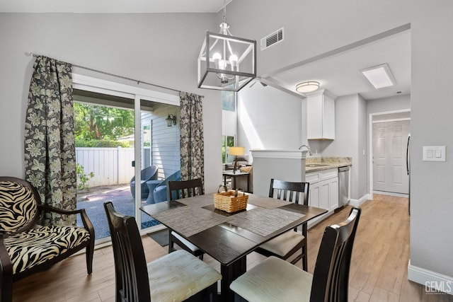 8000 Kroll Way Unit 29, Bakersfield, CA 93311 - dining area featuring light wood-type flooring, a chandelier, baseboards, and high vaulted ceiling