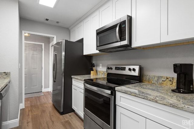8000 Kroll Way Unit 29, Bakersfield, CA 93311 - kitchen featuring appliances with stainless steel finishes, white cabinets, light wood-style flooring, baseboards, and light stone countertops